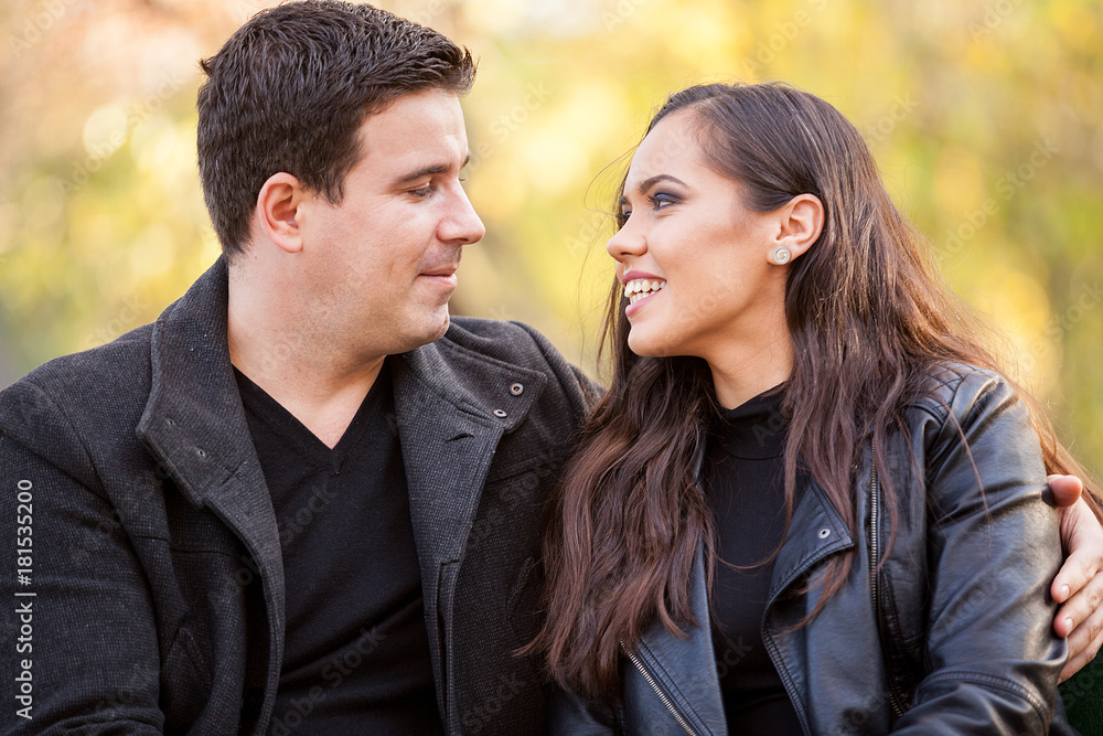 Close up of happy beautiful in love couple sitting on a bench in autumn park Close up of happy beautiful in love couple sitting on a bench in autumn park