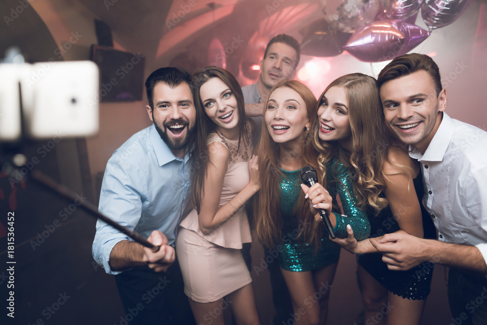 Young people in the club sing songs, dance and make selfies on a smartphone with self-stick. Young people in the club sing songs, dance and make selfies on a smartphone with self-stick.