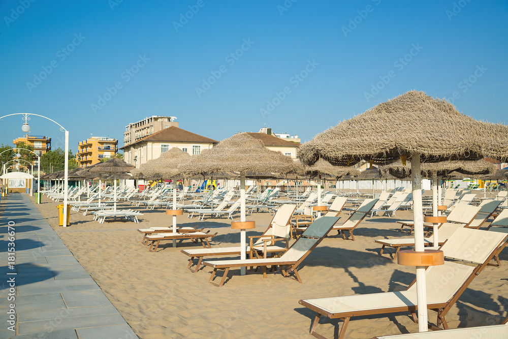 Umbrellas and chaise lounges on the beach of Rimini in Italy