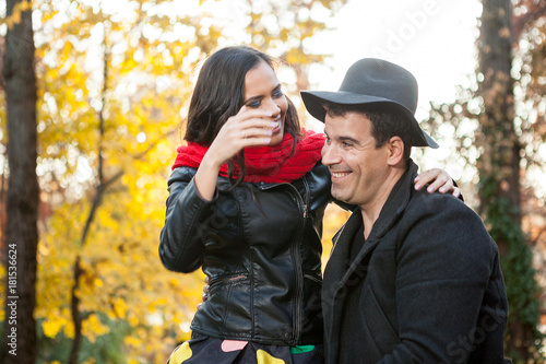 Romantic couple in autumn park smiling and having fun