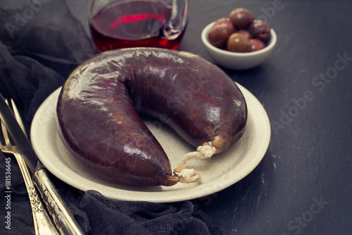 smoked blood sausage on white dish on wooden background photo