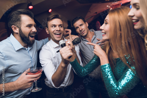Young people have fun in a nightclub. Three men and three women staged a musical battle.