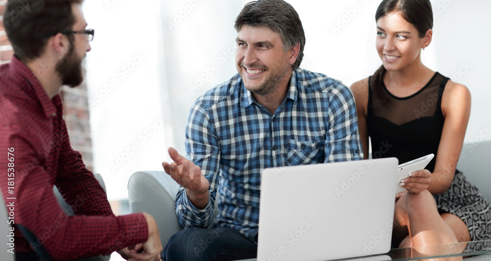 Portrait of smiling executives sitting with laptop in office Portrait of smiling executives sitting with laptop in office