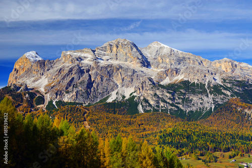 Scenic view of the Tofane Group and golden larch in sunlit at autumn morning. Dolomites, South Tyrol. Italy