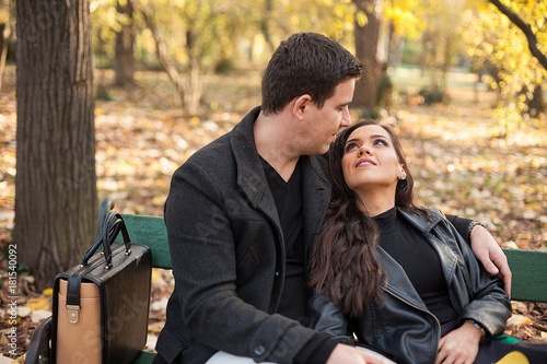In love happy young couple sitting on a bench in autumn park © DC Studio
