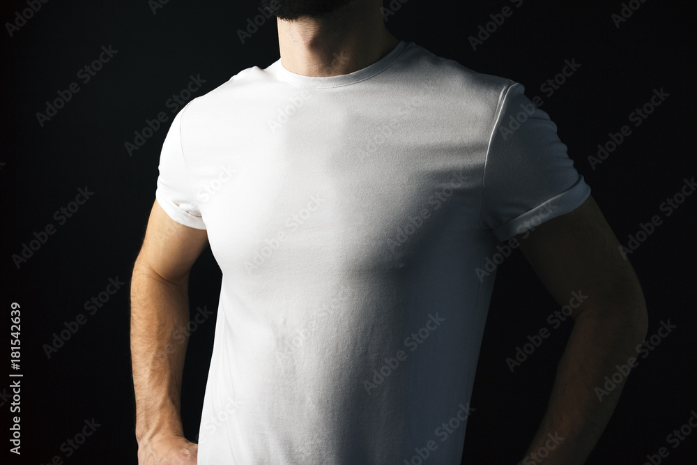 Model male in white empty t short on black bacground. Muscular body in white blank t-shirt Model male in white empty t short on black bacground. Muscular body in white blank t-shirt