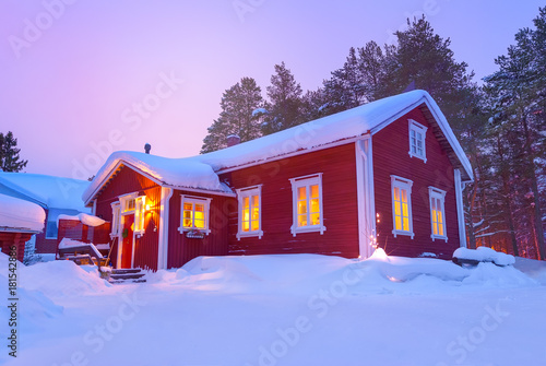 Wooden cottage Finnish house covered with snow in winter