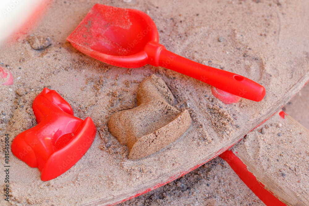 toys in a sandbox, a scoop and a horse's shape toys in a sandbox, a scoop and a horse's shape