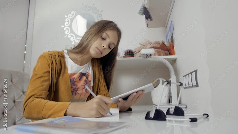 education, school, technology and internet concept - little student girl with tablet pc at school or home doing homework education, school, technology and internet concept - little student girl with tablet pc at school or home doing homework