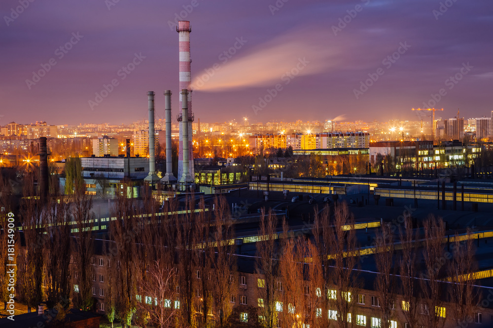 Night cityscape view of Voronezh. Industrial area, pipes of factory are polluting air