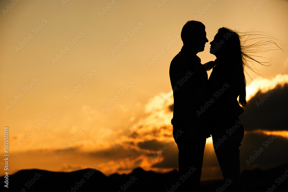 Silhouette of couple kissing at sunset