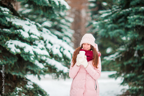 Happy girl enjoy winter and snow weather outdoors on beautiful wonter day photo