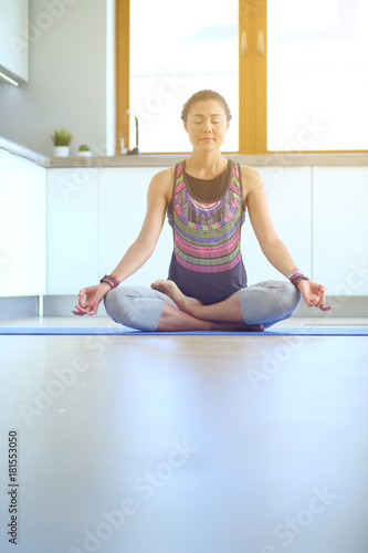 Young woman doing yoga at home in the lotus position. Yoga. Woman. Lifestyle