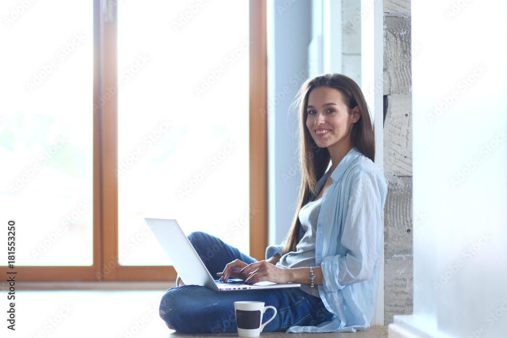 Young beautiful woman at home sitting on the floor with laptop. Young beautiful woman. Young beautiful woman at home sitting on the floor with laptop. Young beautiful woman.