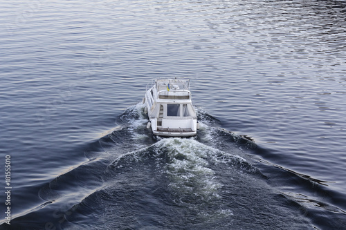 Speedy luxury white motor boat on the water surface. Transport