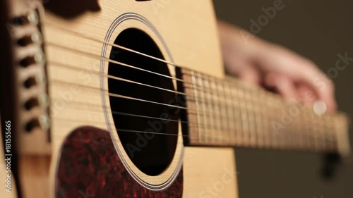 Close up, person tunes guitar strings