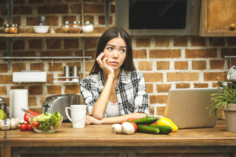 Young beautiful asian stressed woman with laptop on kitchen. Working home. In stress. Freelance