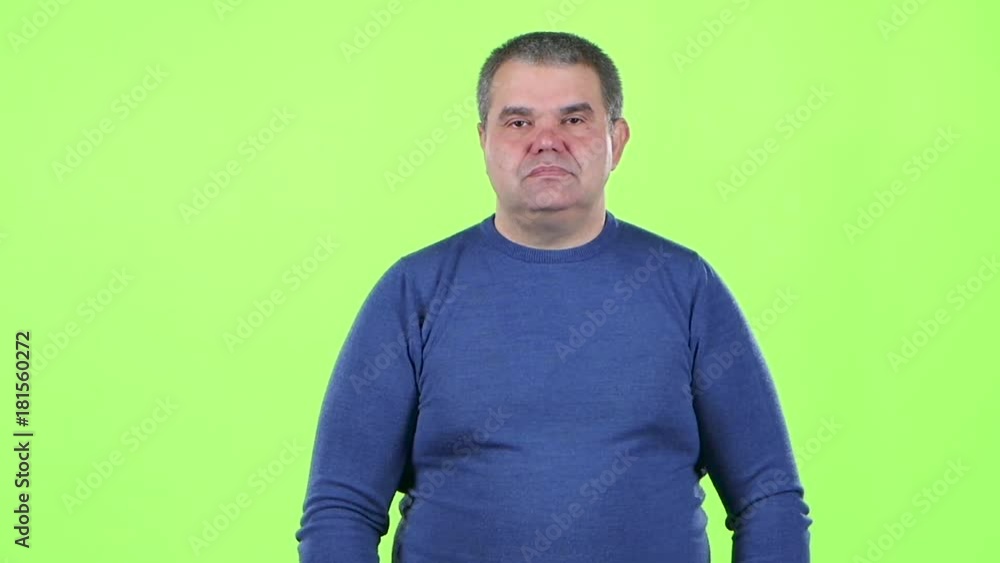 Man is not emotional standing in the studio. Green screen. Slow motion. Slow motion Man is not emotional standing in the studio. Green screen. Slow motion. Slow motion