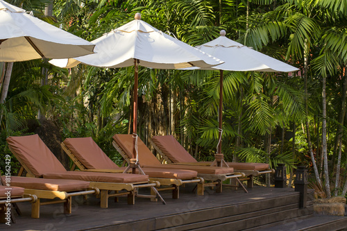 Beach loungers and umbrellas on the beach next to sea in tropical hotel  Thailand