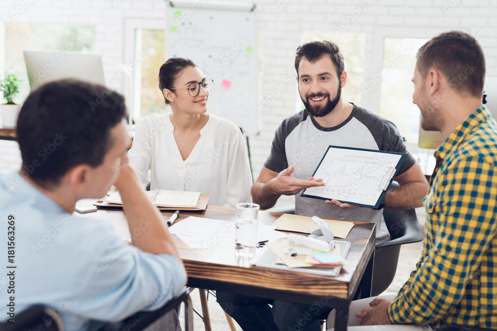 A man demonstrates business graphics. His collegues are listening to him. A man demonstrates business graphics. His collegues are listening to him.