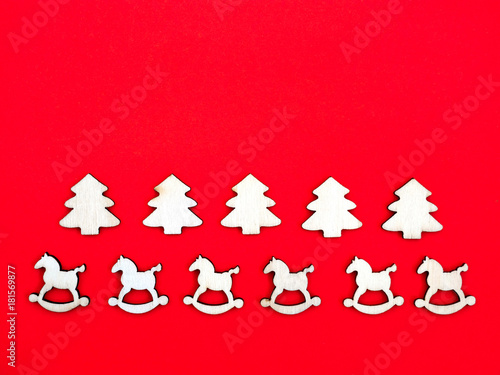 wooden horses and pine trees on bright red background