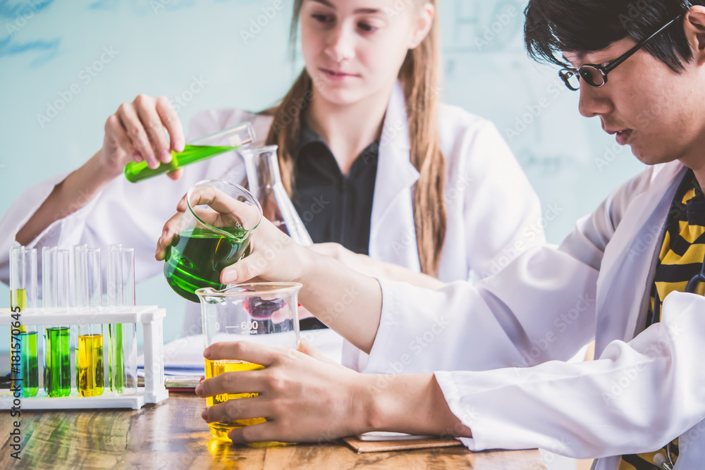 Couple of students working at chemistry class. Education concept Couple of students working at chemistry class. Education concept