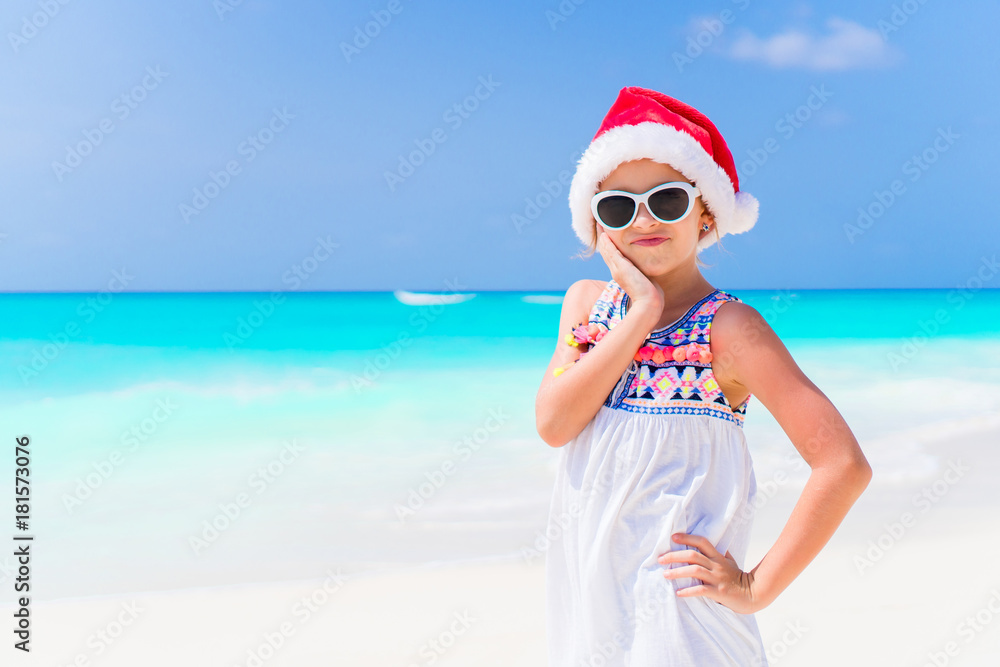 Adorable little girl in Santa hat during Christmas beach holiday Adorable little girl in Santa hat during Christmas beach holiday