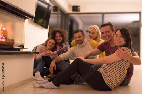 multiethnic couples sitting in front of fireplace