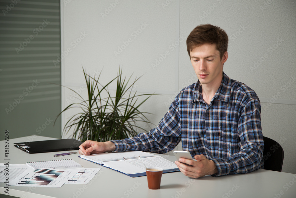 entrepreneur in casual clothes sitting at a table, studying documents