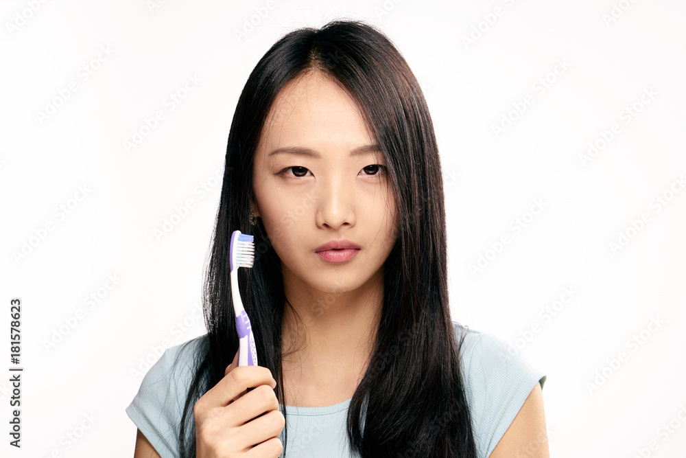 1978337 Asian, woman on white isolated background holds toothbrush 1978337 Asian, woman on white isolated background holds toothbrush