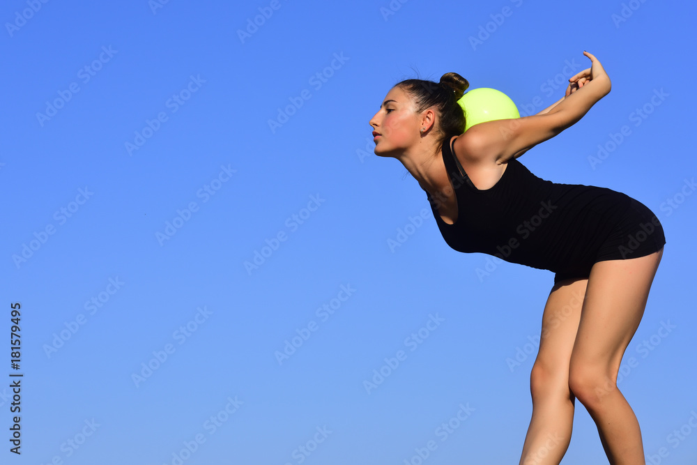 Woman gymnast in black sportswear with green ball. Woman gymnast in black sportswear with green ball.