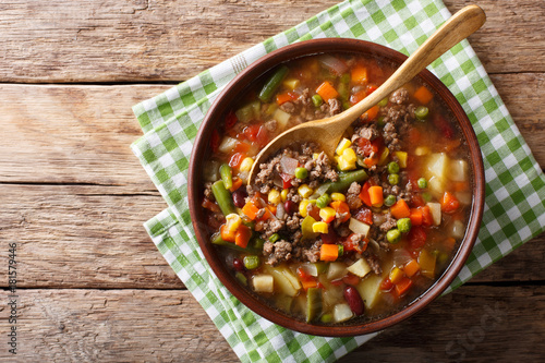 Vegetable soup with ground beef close-up in a bowl. horizontal top view