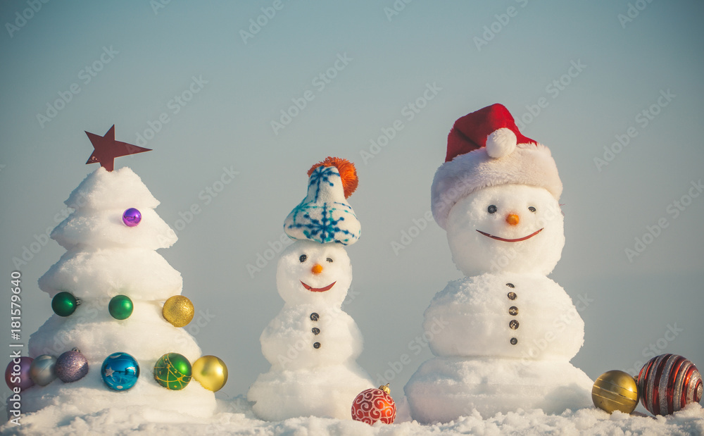 Snowmen with smiley faces in hats on winter day Snowmen with smiley faces in hats on winter day