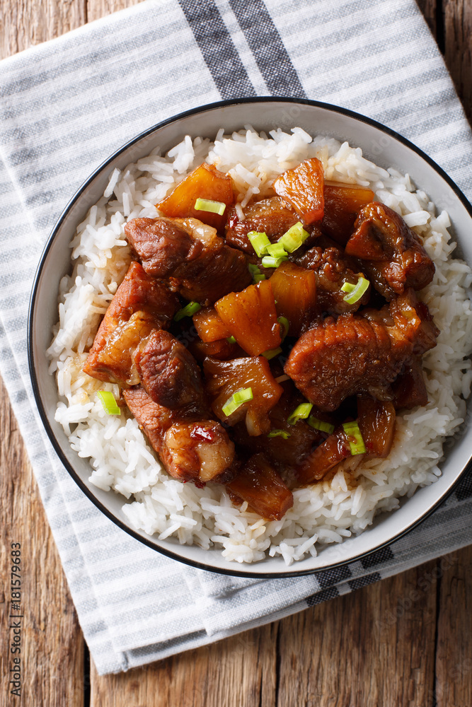 Philippine cuisine: Hamonado pork with pineapple and garnish of rice close-up. Vertical top view Philippine cuisine: Hamonado pork with pineapple and garnish of rice close-up. Vertical top view