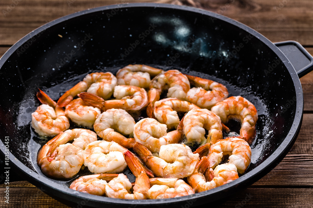 Fried shrimp with garlic on pan, preparing dish with seafood, mediterranean cuisine concept Fried shrimp with garlic on pan, preparing dish with seafood, mediterranean cuisine concept