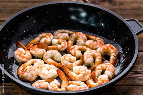 Fried shrimp with garlic on pan, preparing dish with seafood, mediterranean cuisine concept