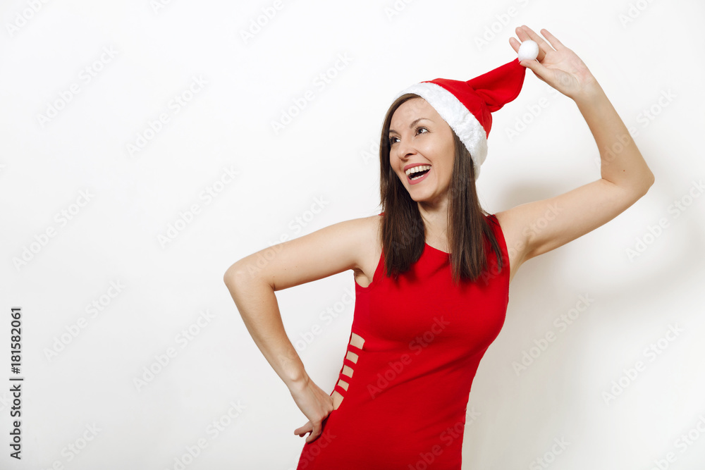 Beautiful caucasian young happy woman with healthy skin and charming smile wearing red dress holding Christmas hat on white background. Santa girl isolated portrait. New Year holiday 2018 concept Beautiful caucasian young happy woman with healthy skin and charming smile wearing red dress holding Christmas hat on white background. Santa girl isolated portrait. New Year holiday 2018 concept