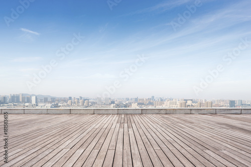 empty wooden floor with modern cityscape in foggy day