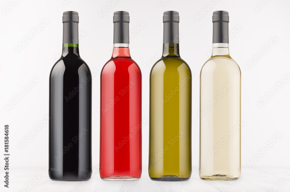 Wine bottles collection different colors on white wooden board, mock up. Template for advertising, design, branding identity. Wine bottles collection different colors on white wooden board, mock up. Template for advertising, design, branding identity.