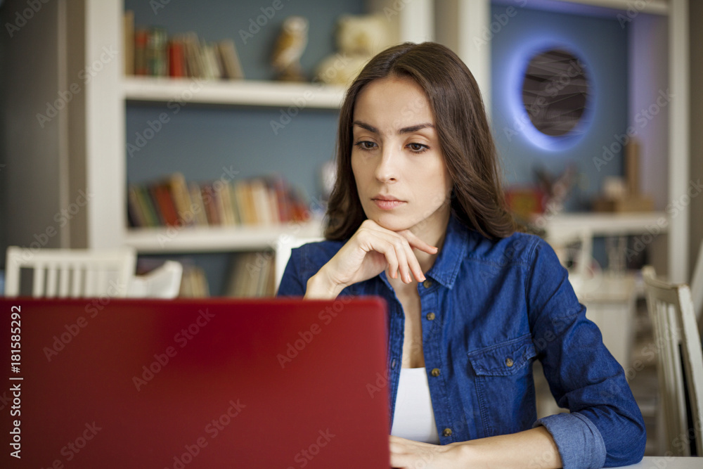 Beautiful smiling young brunette women sitting at the table and working at a laptop. Co working zone. Pretty freelancer. Beautiful smiling young brunette women sitting at the table and working at a laptop. Co working zone. Pretty freelancer.