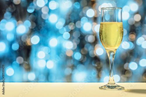 A glass of champagne in his hand on a bright blurred background.