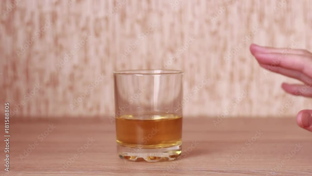 Tremored hand taking a glass of whiskey Tremored hand taking a glass of whiskey