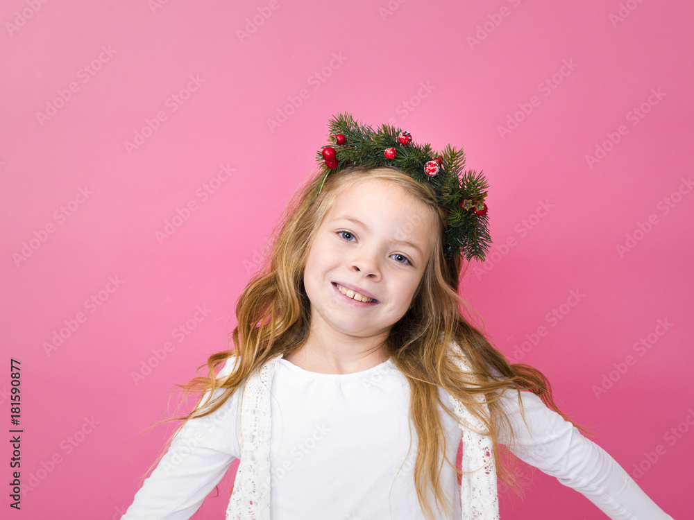 beautiful blond girl with christmas decoration on her head in front of pink background beautiful blond girl with christmas decoration on her head in front of pink background