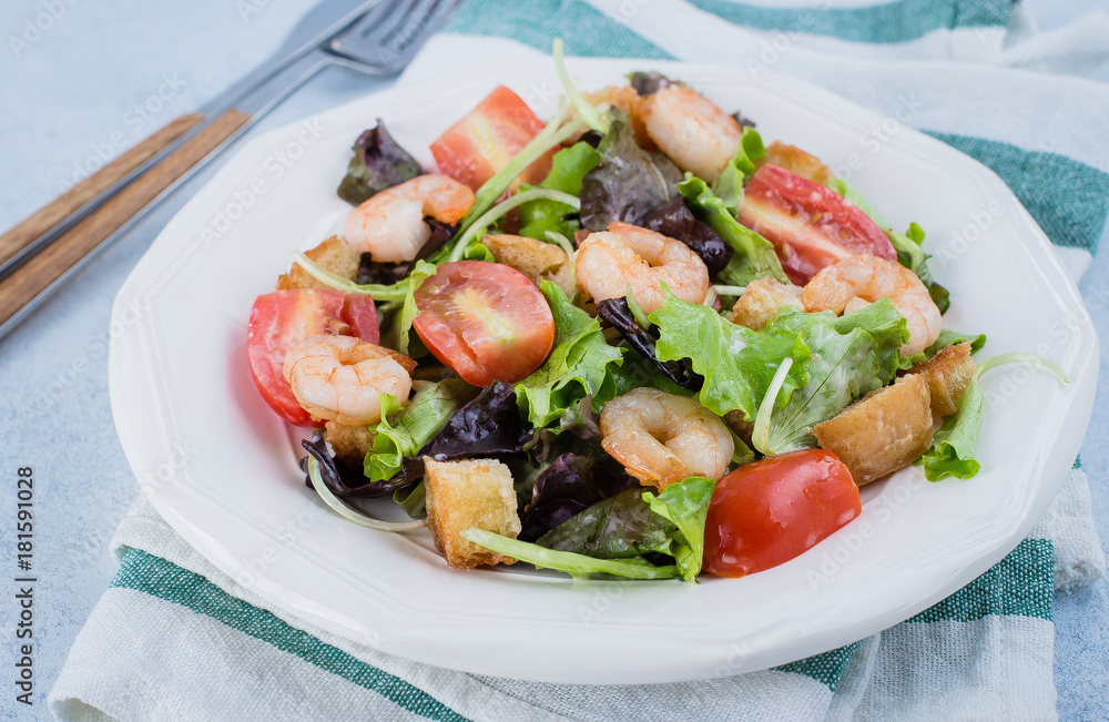 Fresh caesar salad on white plate with lettuce, cherry, parmesan cheese and shrimps on stone table background. Healhty Food Snack Concept. Top view Copy Space Fresh caesar salad on white plate with lettuce, cherry, parmesan cheese and shrimps on stone table background. Healhty Food Snack Concept. Top view Copy Space