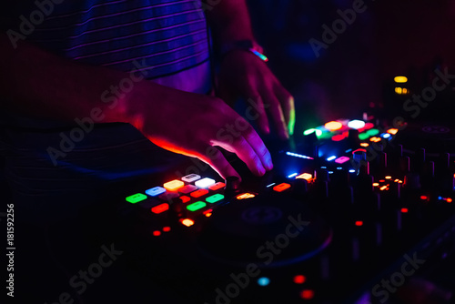 hands of modern DJ professional mixer and music Board of the controlling buttons and levels