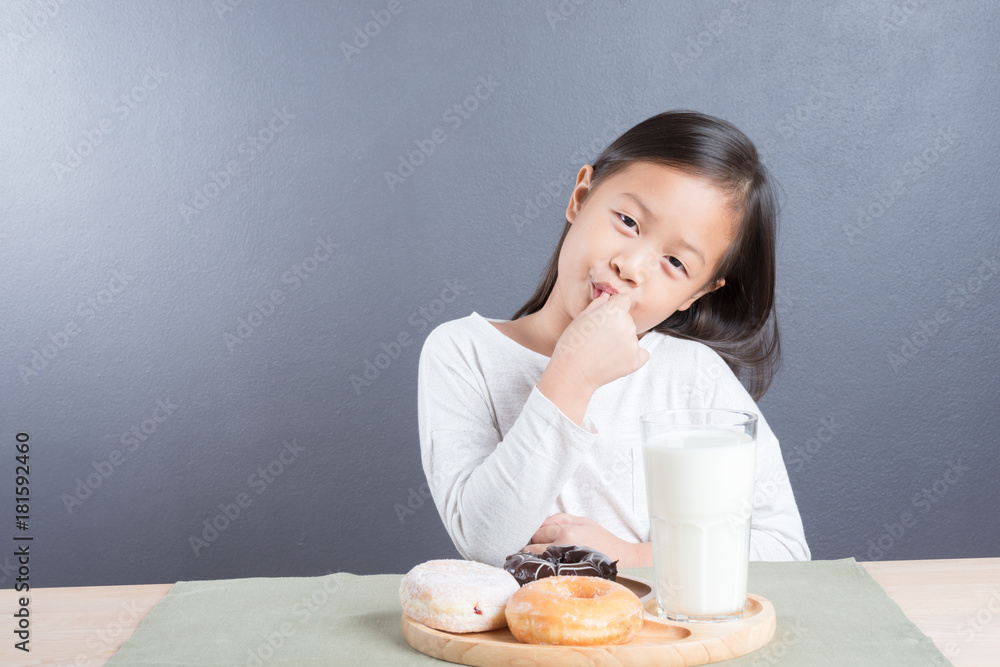 Asian kid girl happy to eat doughnut and milk Asian kid girl happy to eat doughnut and milk