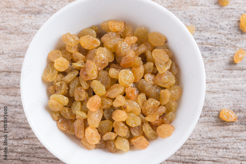 Dried yellow raisin fruits on wood background Dried yellow raisin fruits on wood background