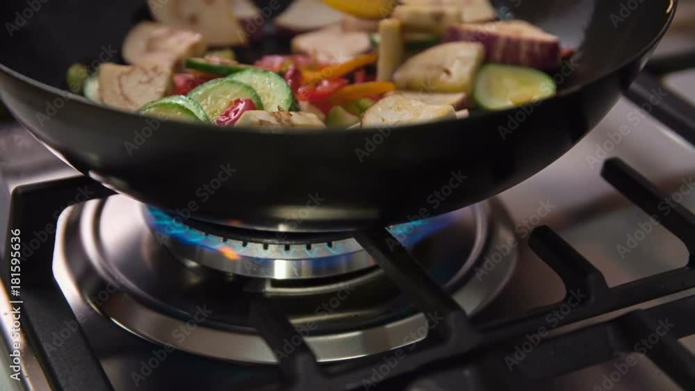 Stirring delicious colourful vegetables that are cooking in a wok. Cook will definitely surprise his demanding guests. Stirring delicious colourful vegetables that are cooking in a wok. Cook will definitely surprise his demanding guests.