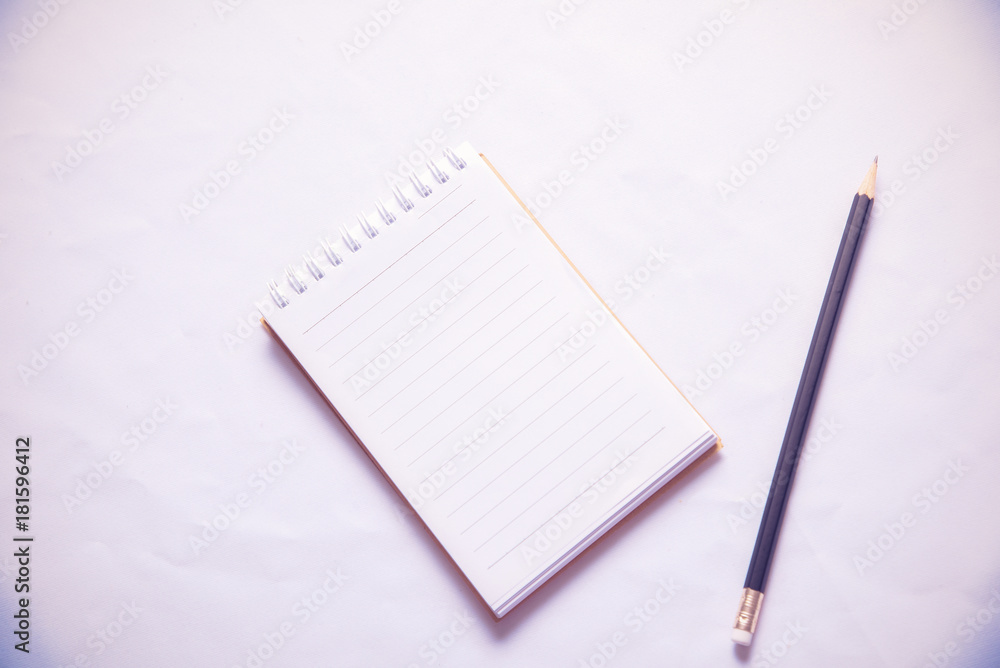 Black pencil and Notebook paper on white background Black pencil and Notebook paper on white background