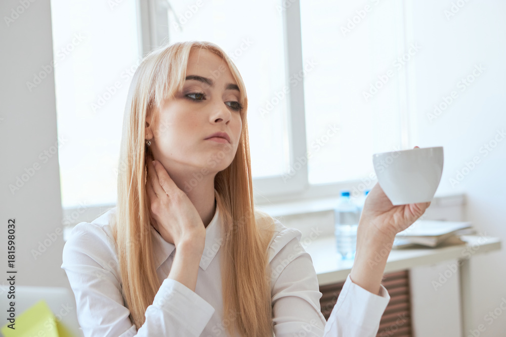 Beautiful young woman holding a mug in the office Beautiful young woman holding a mug in the office